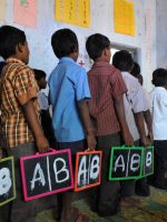 Indian schoolchildren stand in line with English alphabets written on their slates at a government primary school in the outskirts of Hyderabad on June 13, 2011, on the opening day of the new academic year. The government of India's Andhra Pradesh state has introduced English as a second language from Class 1 onwards for the 2011-2012 academic year. India's National Knowledge Commission has admitted that no more than one percent of country's population uses English as a second language. AFP PHOTO/Noah SEELAM
